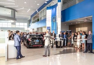 John Eagle, CEO of John Eagle Auto Group, speaks to a crowd gathered for the grand opening of Hill Country Honda