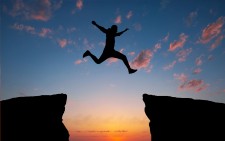 Silhouette of a Person Leaping Over a Gap