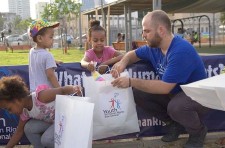 Scientologists hand out toys and clothing they collected to refugee children