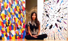 Leto Lama surrounded by her paintings 'The Gathering' and 'Energy'