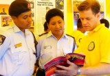 Volunteer Minister goes over the booklet for one of the courses with to police officers at a Volunteer Ministers tent. The courses that are available online are also offered free of charge through Scientology Volunteer Ministers cavalcades and goodwill tours.