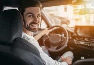 Friendly Driver Smiling from Front Seat of Car