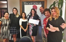 Exceptional Minds' Ernie Merlán accepts a check from Mary-Elizabeth Michaels, Director of Community Affairs for Warner Bros.  