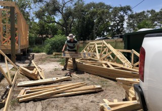 Volunteer cuts plywood for home rebuild