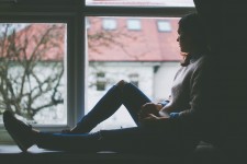 Woman Looking out a Window from Shadows