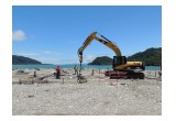 Ram Jack installing helical piles in sandy waterfront area