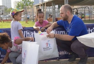 Scientologists hand out toys and clothing they collected to refugee children