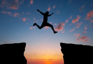 Silhouette of a Person Leaping Over a Gap