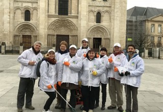 Volunteers from The Way to Happiness Foundation of France gather to launch a neighborhood cleanup.