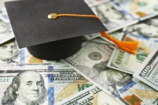 Graduation Cap Sitting on Hundred Dollar Bills