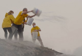 Scientology Volunteer Ministers preventing blowing embers from spreading the fire to undamaged buildings.