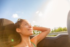 Woman relaxing in car not worried about student loans